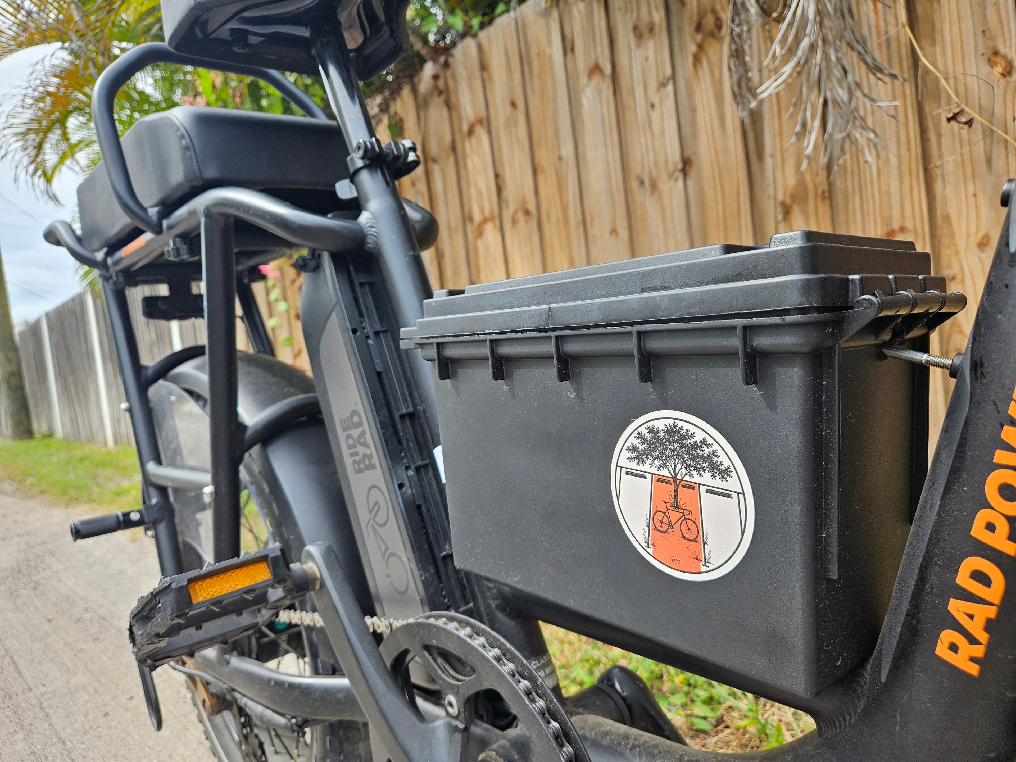 OCCUPIED sticker on a black delivery box mounted to a black-and-orange bicycle